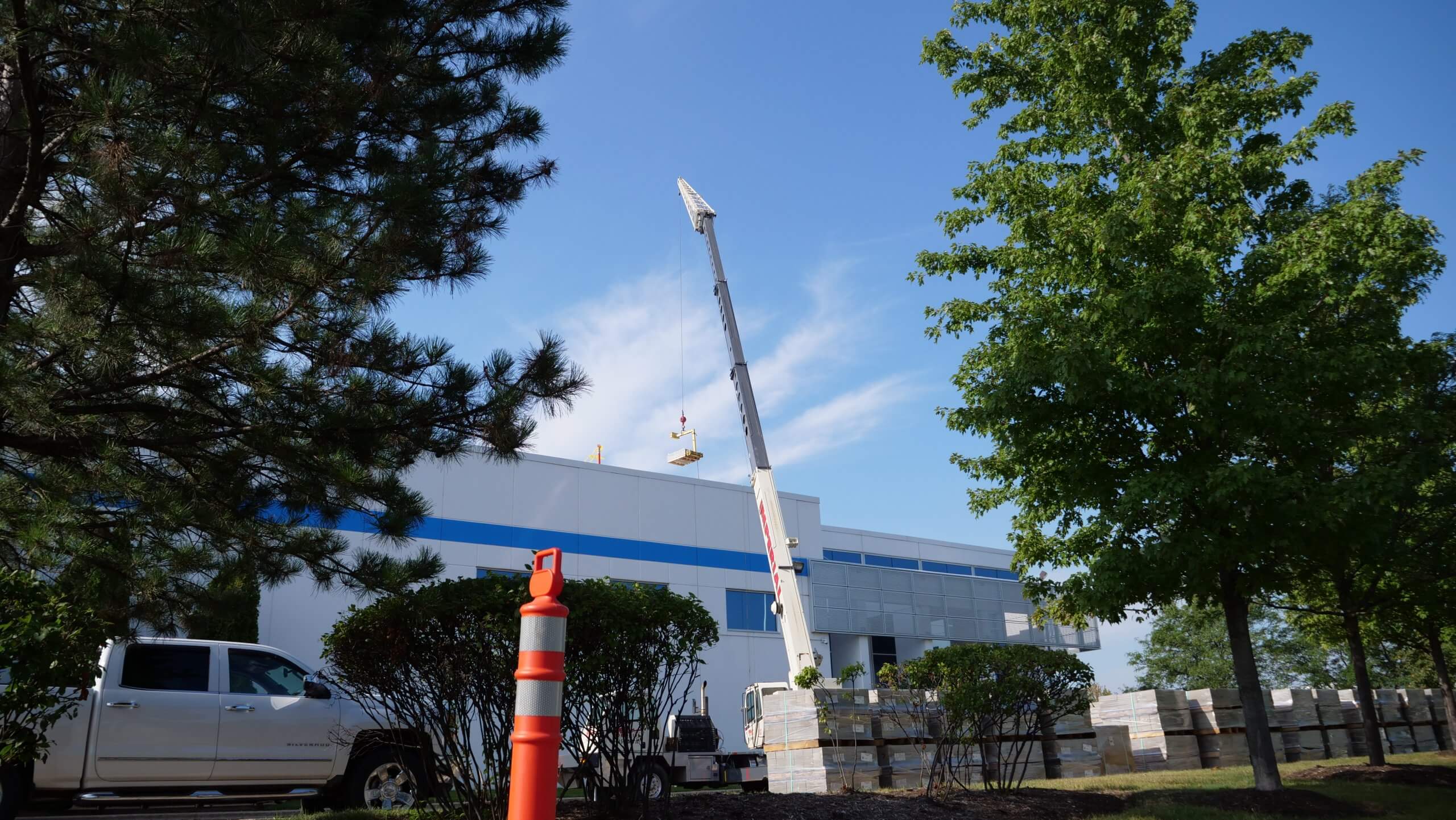 A crane lifting objects on to the roof of a building
